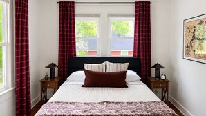 A bedroom with a bed, two bedside tables, a ceiling fan, and a window with curtains. - Located in the IU Tailgate Fields - Across from Memorial Stadium (Bloomington)