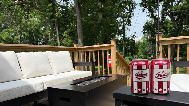 Un área de estar al aire libre con un sofá, una mesa y dos latas de cerveza.