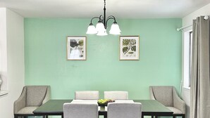 Un comedor con una mesa, sillas y dos lámparas fijadas a la pared.