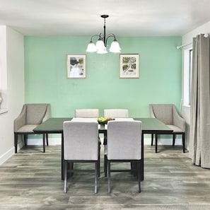 A dining area with a table, chairs, and two wall-mounted light fixtures.