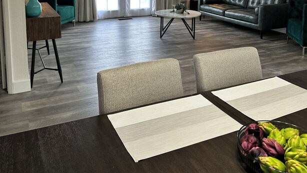 Una sala de estar moderna con un sofá, una mesa de comedor y sillas.