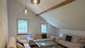 A spacious loft with two sofas, a glass coffee table, and pendant lighting. - Your time-out with a view of the Alps and the Kander (Kandergrund)