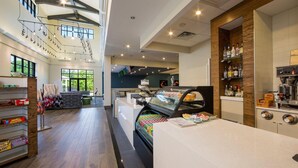 Un vestíbulo amplio con una barra de café, zona de estar y una vitrina con aperitivos.