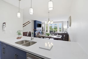 A modern kitchen with a large island, stainless steel appliances, and pendant lighting. - Poolside Fairway Escape | Hot Tub & Golf (The Blue Mountains)
