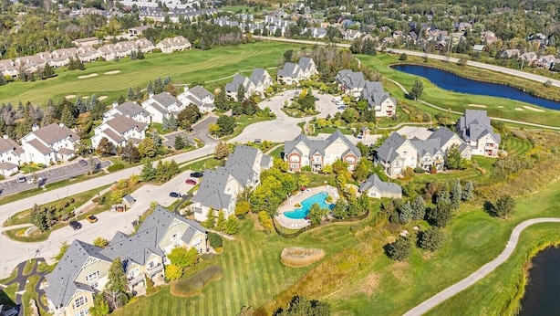 Un quartiere residenziale con case, una piscina e un campo da golf.
