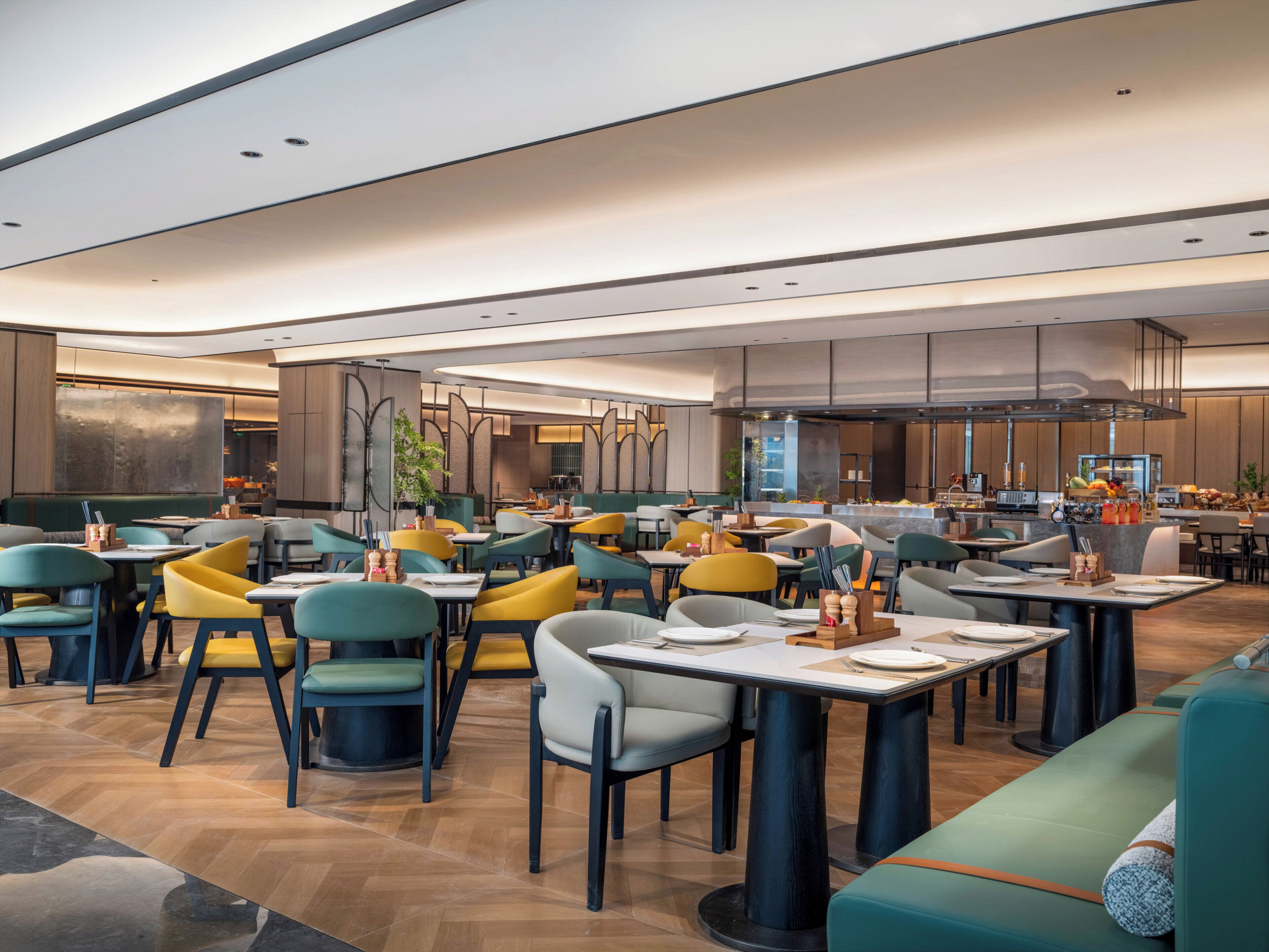 A modern restaurant with high tables and chairs, a bar area, and a seating area with a sofa.
