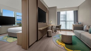 Une chambre d’hôtel moderne équipée d’un lit, d’une télévision, d’un coin repas et d’un canapé.