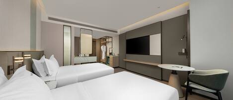 A hotel room with two beds, a TV, a desk, and a chair.