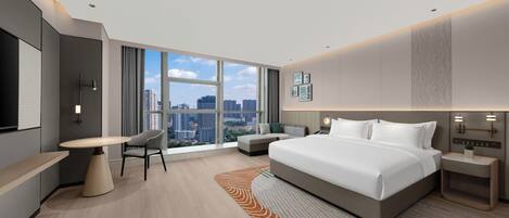 A modern hotel room with a large bed, a desk, a chair, and a view of the cityscape through large windows.