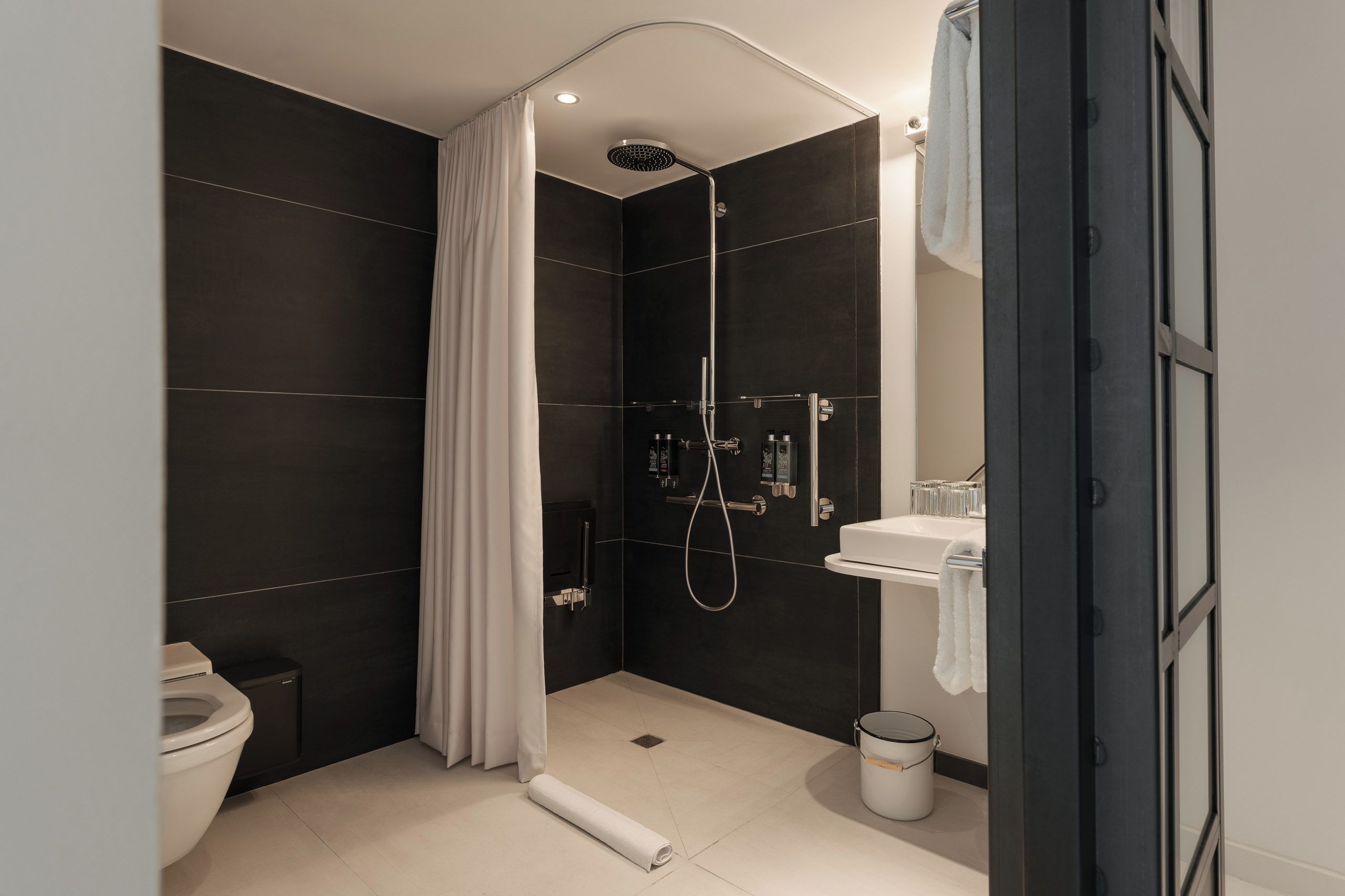 Un baño moderno con ducha, inodoro y lavamanos.