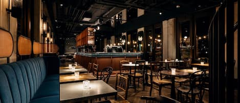 A restaurant interior with booths, tables, and a bar area.