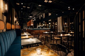 A restaurant interior with booths, tables, and a bar area. - Ruby Lilou Hotel Marseille by IHG (Marseille)