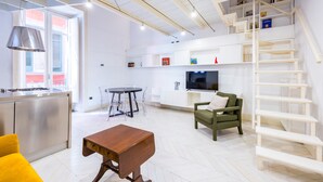 A modern living room with a dining area, kitchen, and a staircase. - Chiaia Prestige by NapoliApartments (Naples)