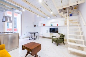A modern living room with a dining area, kitchen, and a staircase. - Chiaia Prestige by NapoliApartments (Naples)