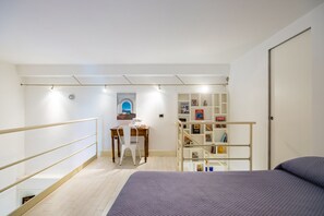 A bedroom with a bed, a desk with a chair, a bookshelf, and a window. - Chiaia Prestige by NapoliApartments (Naples)