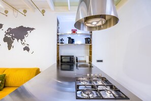 A modern kitchen with a stainless steel countertop, a built-in microwave, and a gas stove. - Chiaia Prestige by NapoliApartments (Naples)