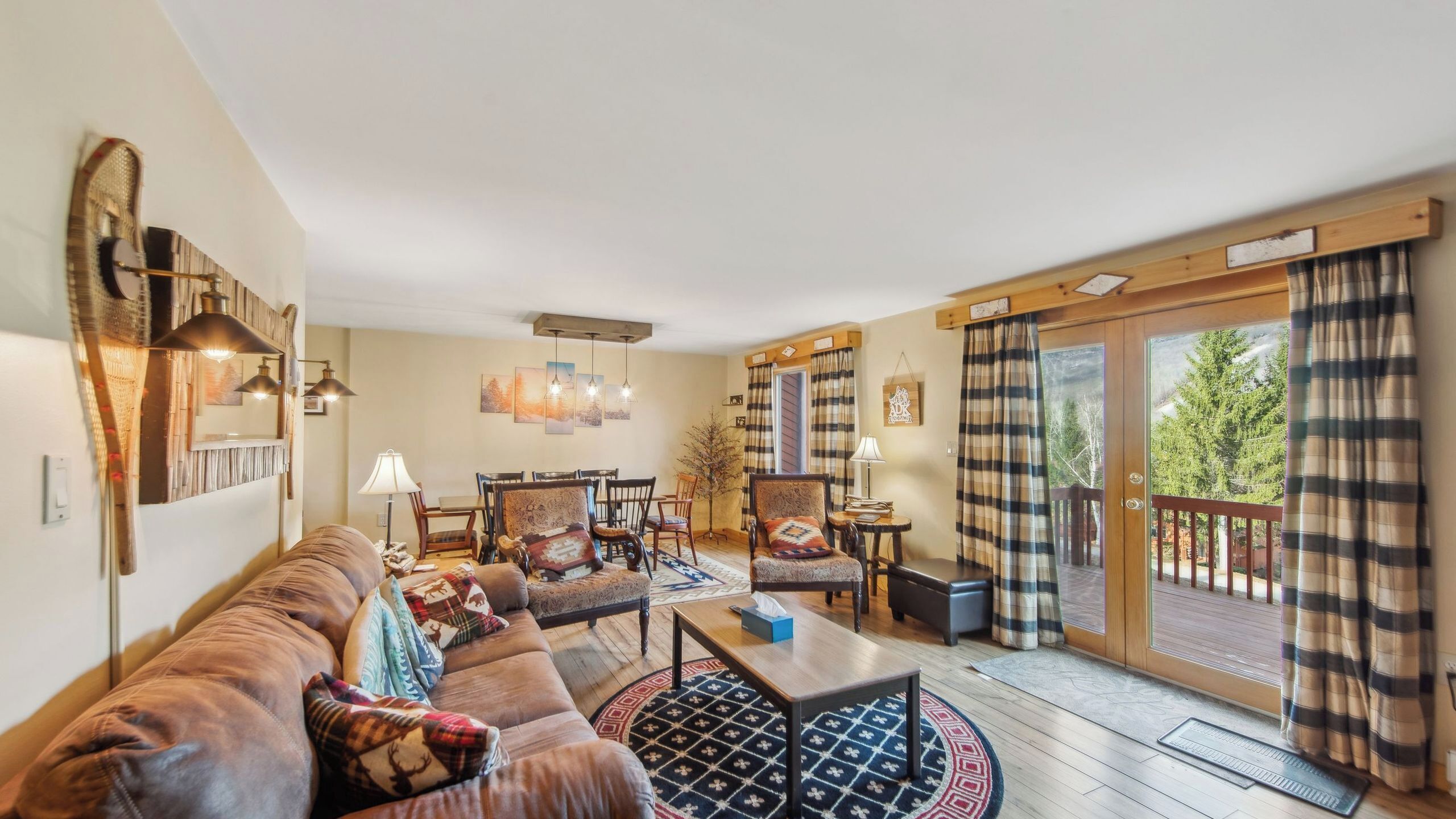 Una sala de estar acogedora con un sofá, sillas, una mesa de centro y un comedor.