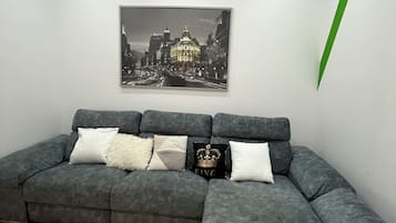 Habitación Deluxe | Área de sala de estar | Televisión de pantalla plana de 54 pulgadas con canales por cable