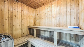 A wooden sauna with benches and a bench with a towel.