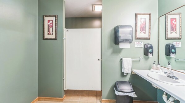 A restroom with a sink, hand soap dispenser, paper towel dispenser, and a trash bin. - Sleeping Bear by Avantstay Heated Pool + Rec Center + Jetted Tub Near Gore Mtn (North Creek)