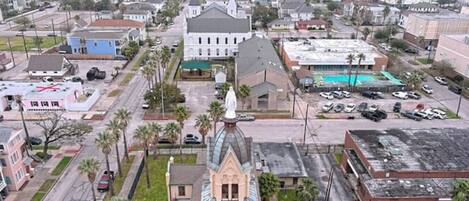 Vue aérienne d’une ville avec une église imposante, un parking et des immeubles d’habitation.