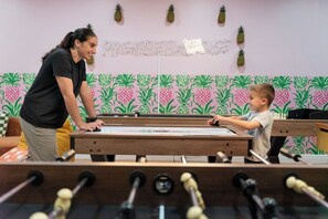 A foosball table in a room with a pineapple-themed wall. - 7BR Private Resort with EPIC SPORT COURT• Pool Cinema • Karaoke (Clearwater)
