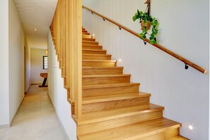 Eine Holztreppe mit Handlauf und einer hängenden Pflanze.