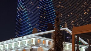 Ein Hotel mit einer klassischen Fassade, großen Fenstern und einer Palme im Vordergrund.