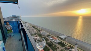 Ein Balkon mit freiem Blick auf das Meer und einen Sonnenuntergang.