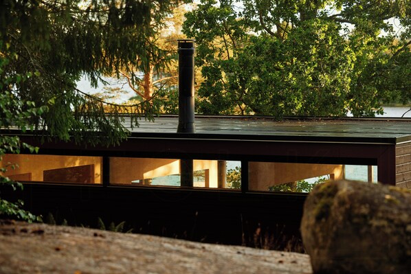 Un edificio moderno con techo plano, ventanas amplias y una chimenea.