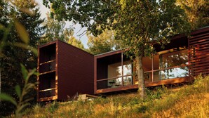 A modern cabin with a glass facade, wooden exterior, and a natural setting. - Architect-designed cabin with Harefjord views (Säffle)