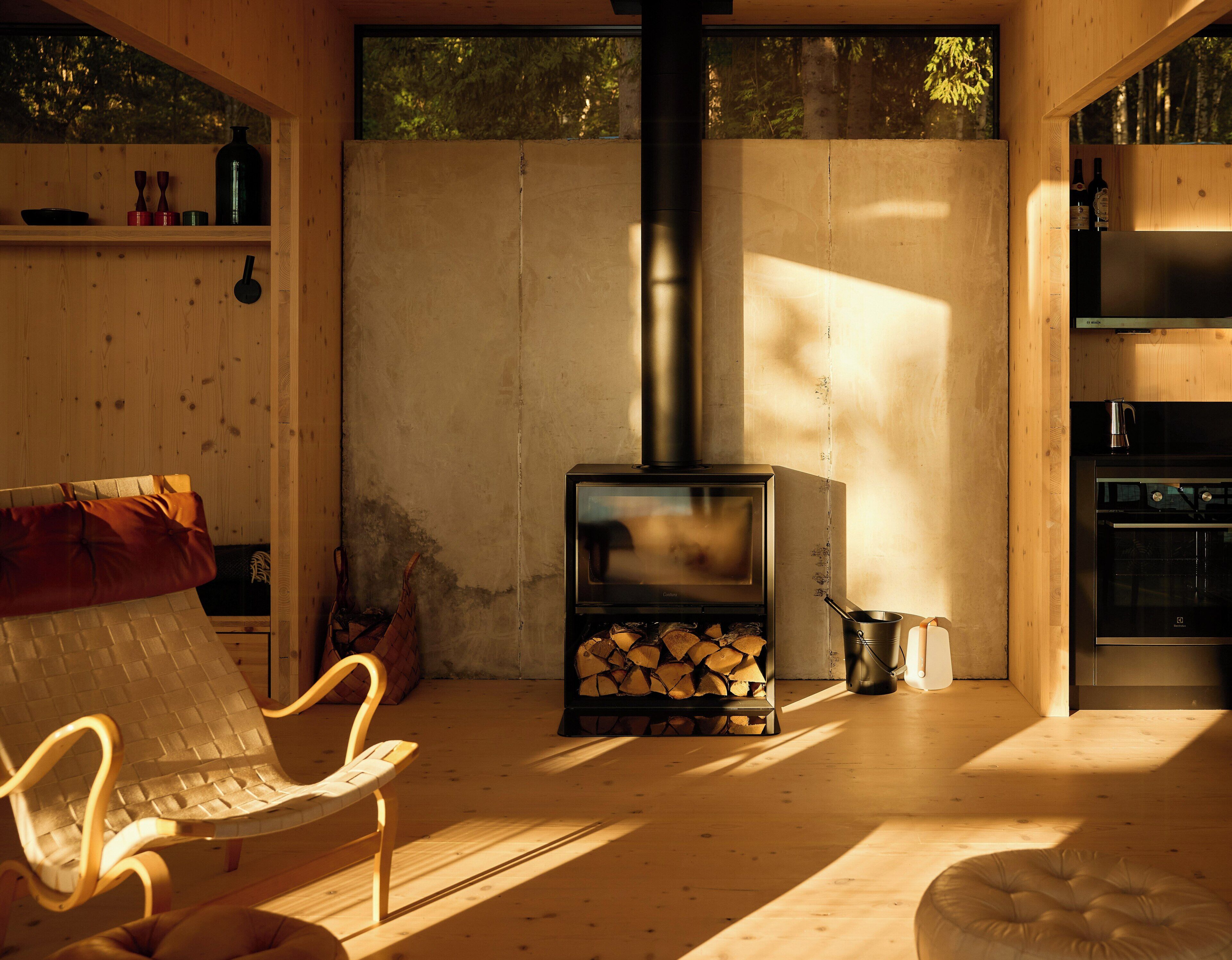 En mysig stuga med en vedeldad kamin, en soffa, en fåtölj och en matplats.