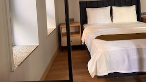 A bedroom with a bed, a nightstand, a window, and a door. - Hotel Karakoy Corner Port (İstanbul)