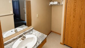 A bathroom with a marble sink, wooden door, and a mirror. - Ste Anne Hotel (Ste Anne)