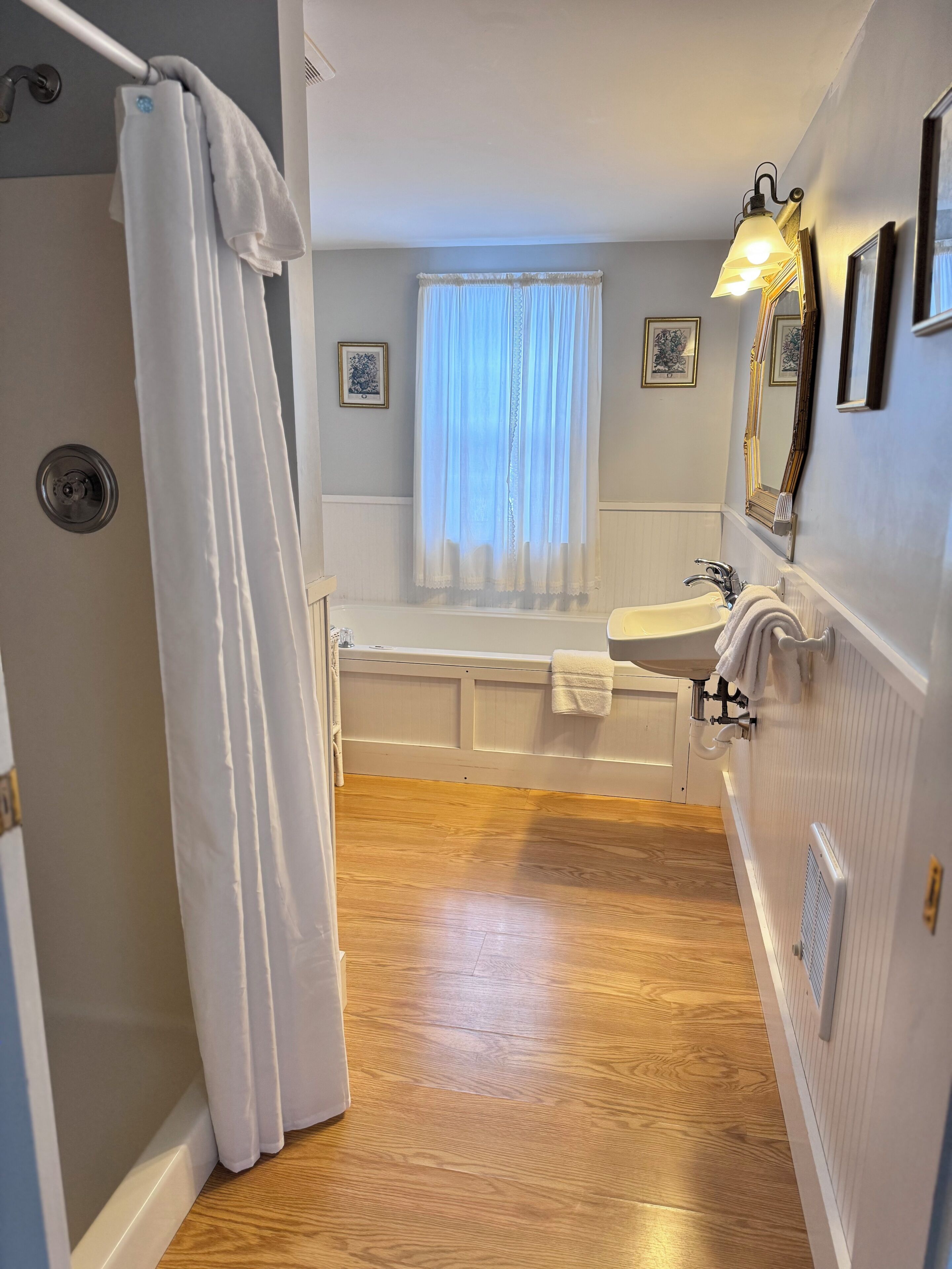 A bathroom with a bathtub, a sink, and a shower curtain.
