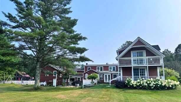 A large two-story house with a front porch and a well-maintained lawn. - The Landgrove (Londonderry)