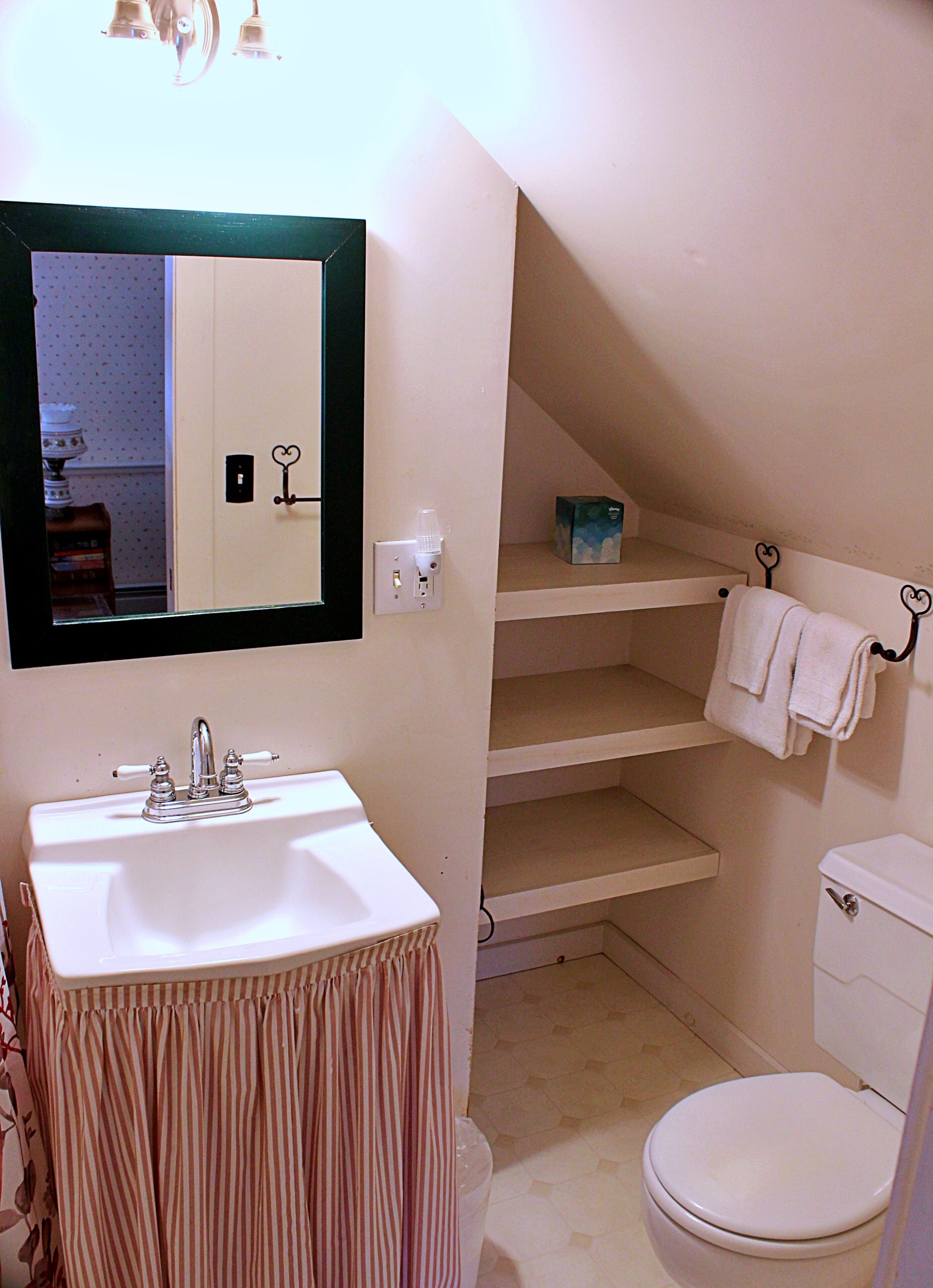 A bathroom with a sink, toilet, and a mirror.