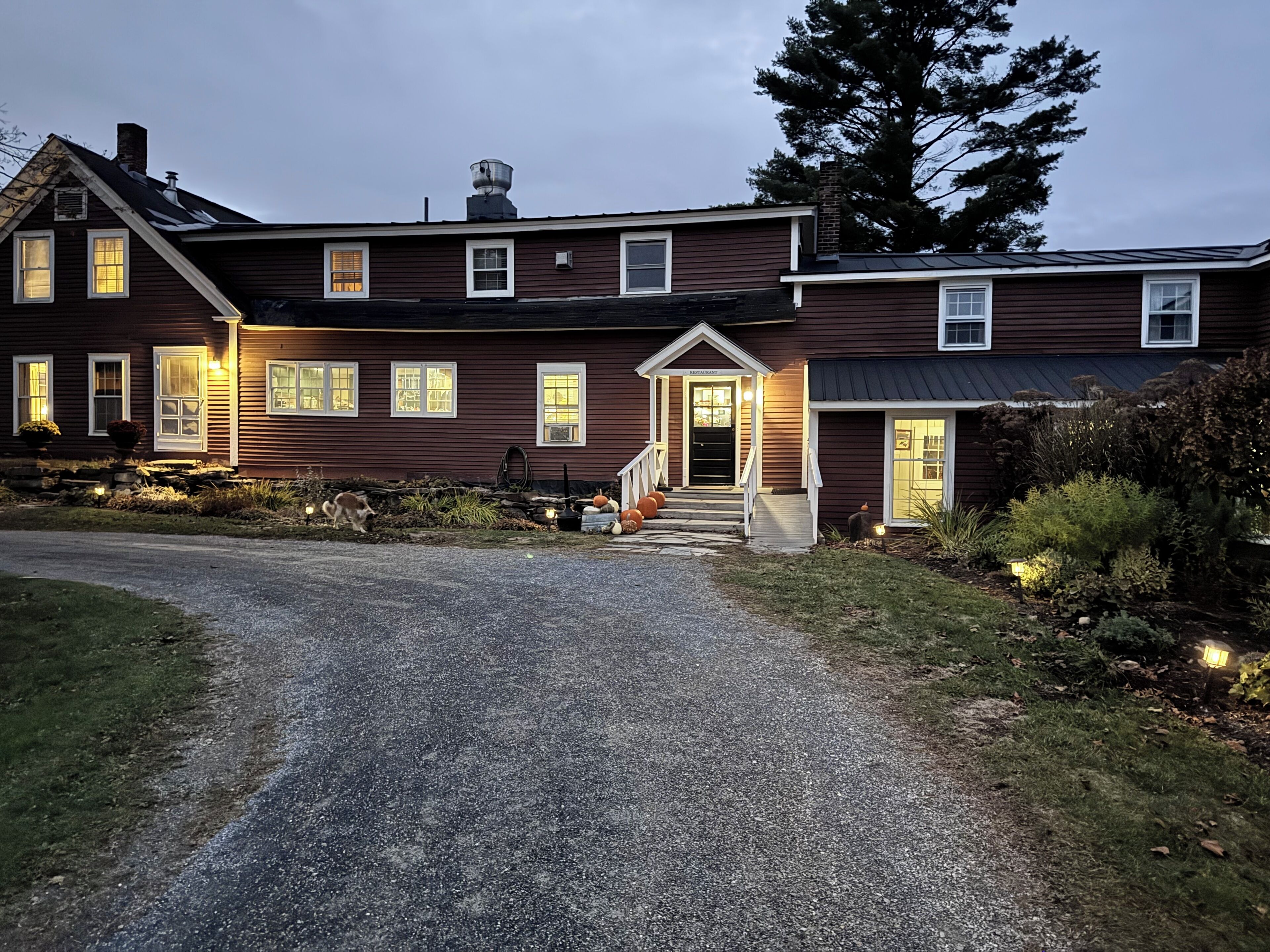 A two-story house with a front porch, a visible entrance, and a driveway leading to the front door.