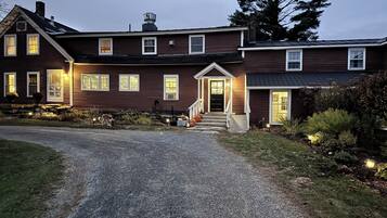 A two-story house with a front porch, a visible entrance, and a driveway leading to the front door.