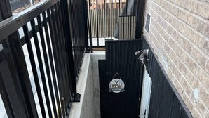 A staircase with black railings, a welcome sign, and a patterned mat at the bottom. - Designer 4BR Basement Suite – Oakville (Oakville)