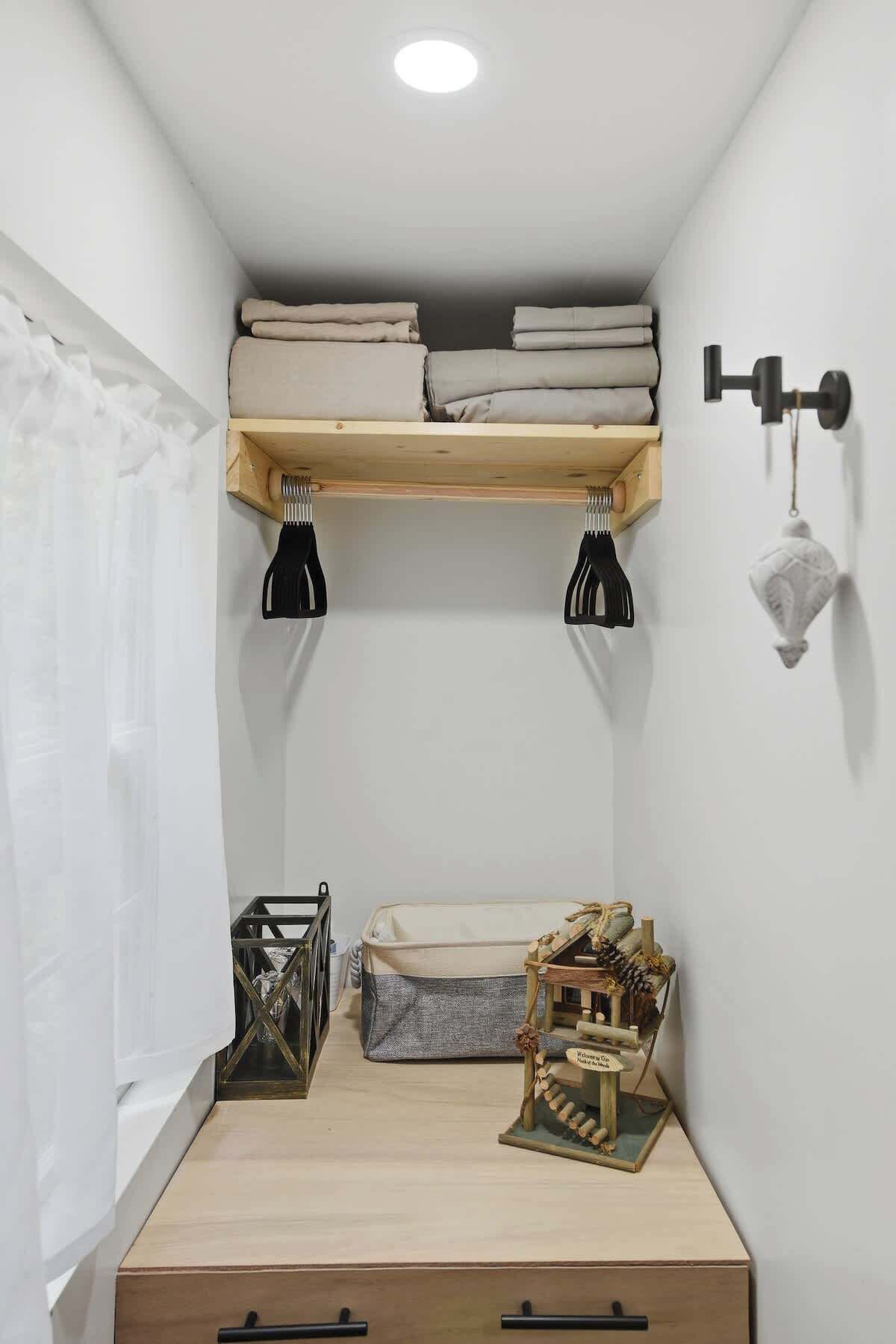 A small, neatly organized room with a bunk bed, a small table, and a decorative model house.