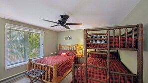 A bedroom with bunk beds, a ceiling fan, a window with blinds, and a wall-mounted lamp. - Hullabaloo by Avantstay Indoor Heated Pool + Game Room Near Gore Mountain (North Creek)