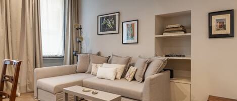 A living room with a sofa, a coffee table, and a bookshelf.