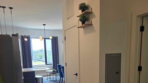 Ett modernt kök med kylskåp, en matplats med bord och stolar samt utsikt genom fönstret.