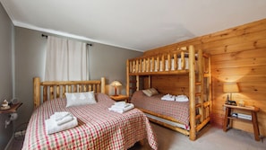 A room with two beds, wooden walls, a window with curtains, a nightstand with a lamp, and a sign indicating 'MOUNTAIN TOP'. - Lower Sleighride by Avantstay Heated Pool + Rec Lounge Near Gore (North Creek)