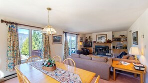 A cozy living room with a fireplace, a dining area with a table and chairs, and a sofa. - Pete Gay by Avantstay Indoor Heated Pool + Rec Center Near Gore Mountain (North Creek)