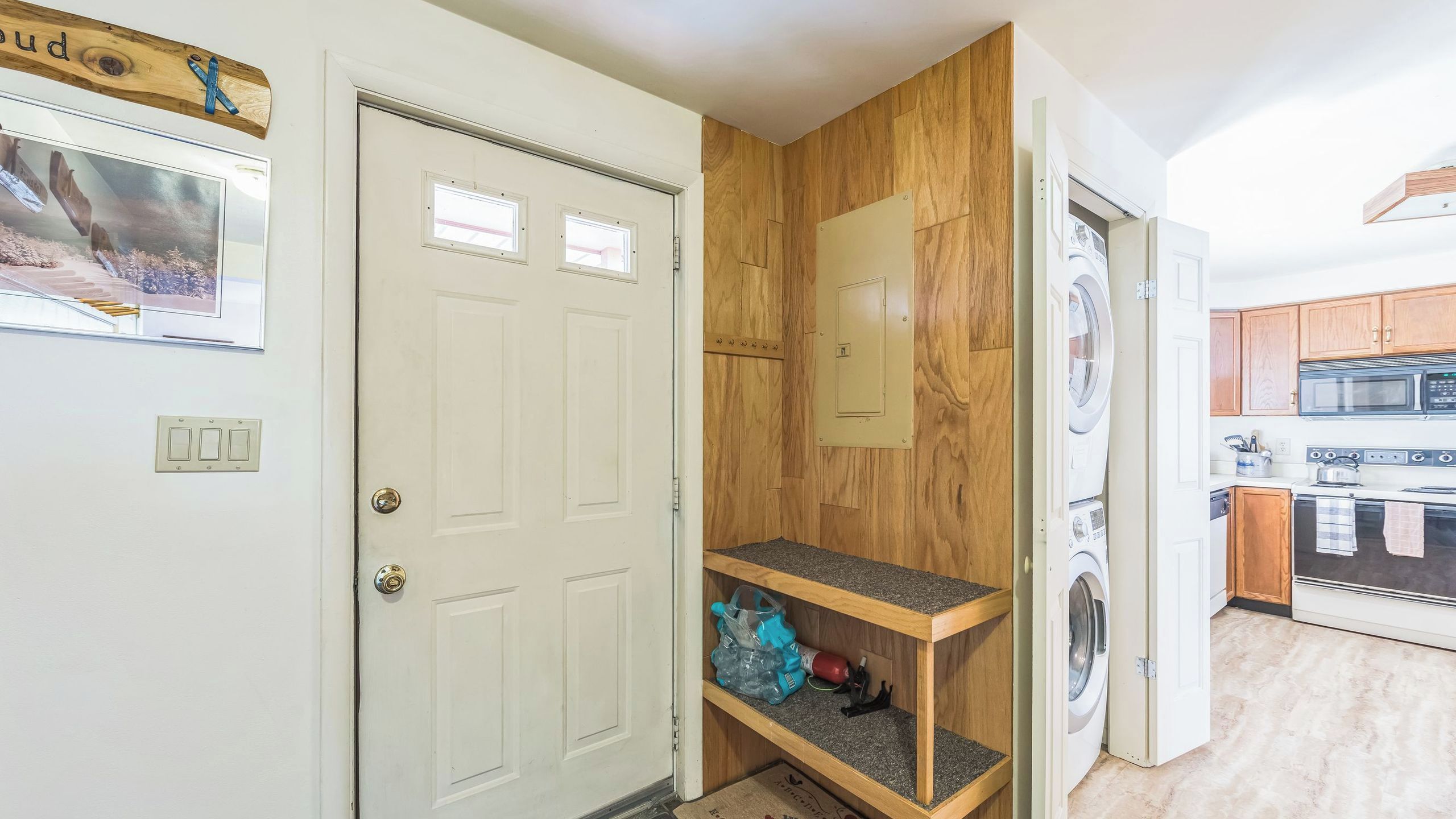A compact kitchen with a microwave, oven, and washing machine.