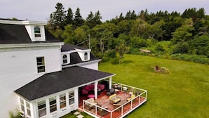 A white house with a covered porch and a lawn. - New Glasgow Inn (New Glasgow)