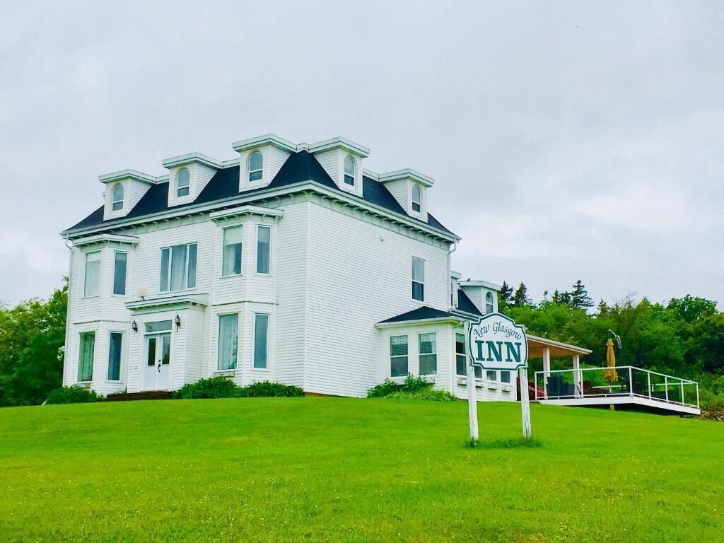 A large white building with a sign reading 'New Glasgow Inn.'