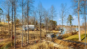 Maaseutumaisema, jossa on järvi, taloja ja rautatie.